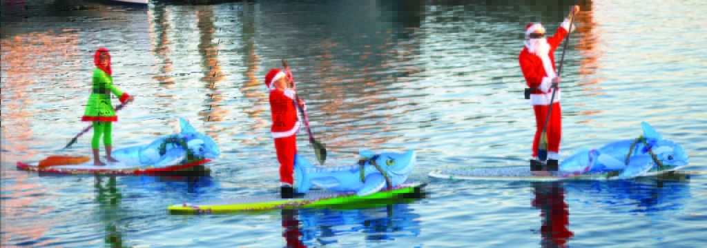 Standup paddleboarders show off their decorative human-powered vessels during the King Harbor Boat Parade.